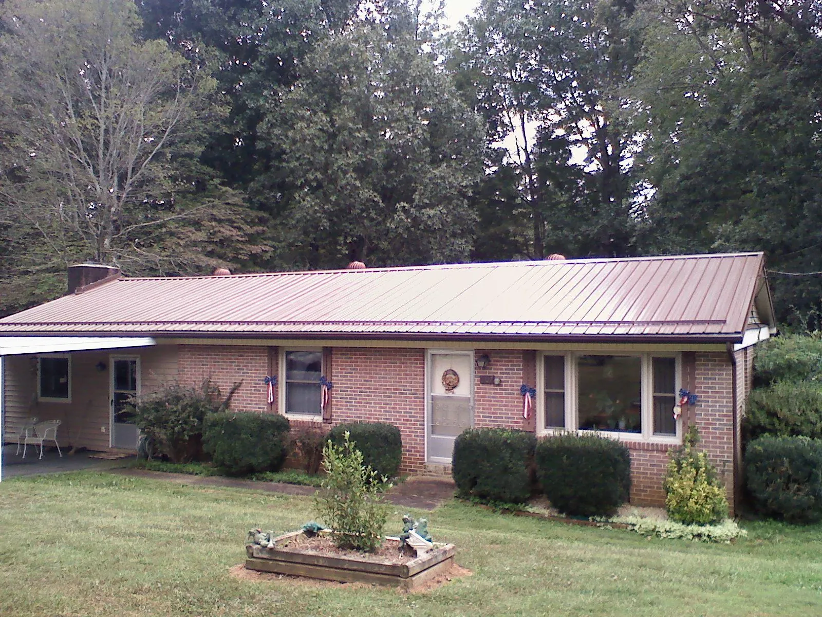 Bronze metal roof on a brick ranch home with a carport in Williamsport